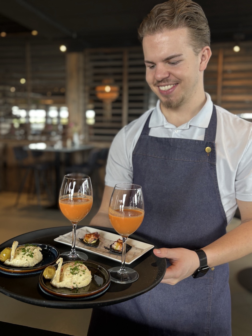 Waiter serving gazpacho and appetisers