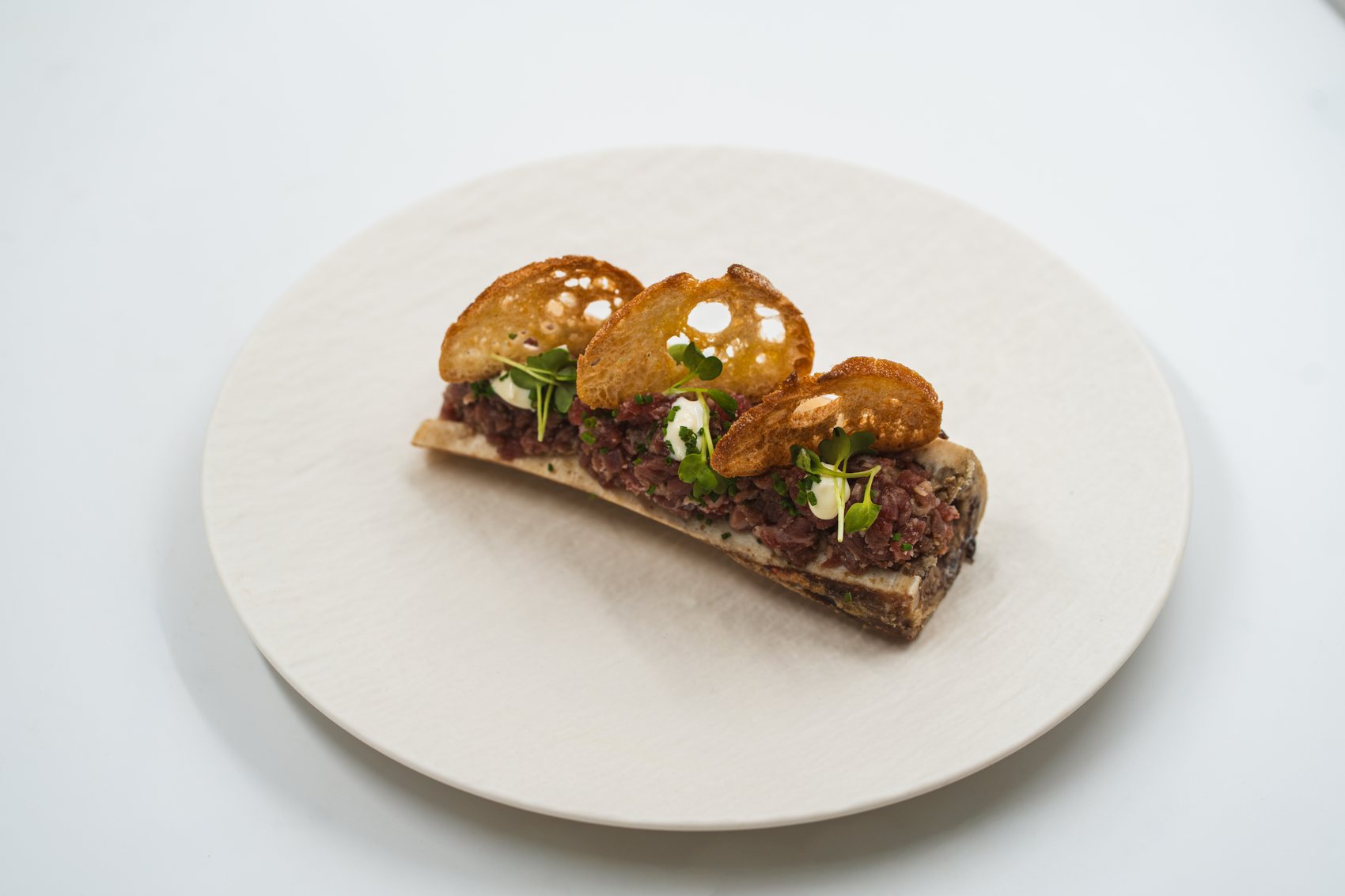 Steak tartare on roasted bone marrow with bread crisps